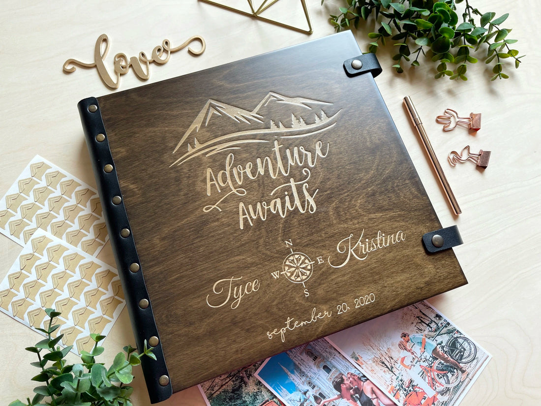 adventure awaits photo album engraved with mountains compass rose and names