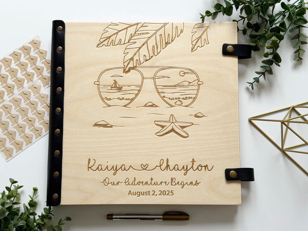 beach vacation photo album engraved with sunglasses reflecting the sea and names