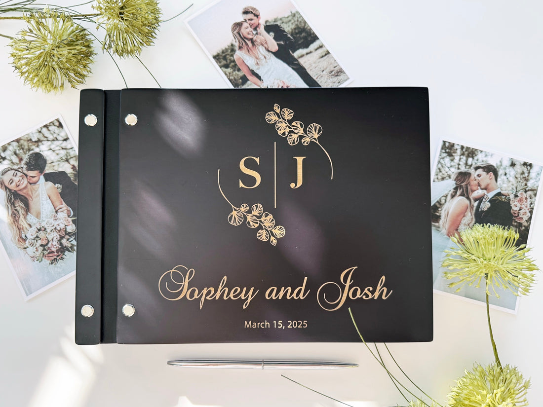 Black wedding guest book with engraved initials and names in light wood tone