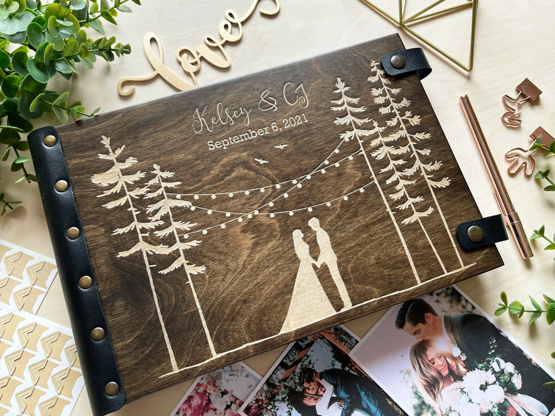forest wedding photo album engraved with pine trees string lights and couple