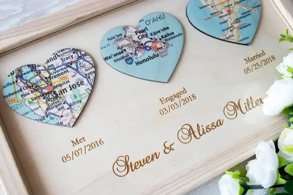 Close up of personalized wooden love story frame with three heart shaped maps for San Jose, Oahu and Okinawa with engraved dates.