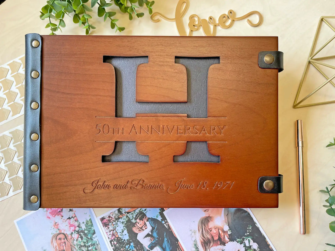 Wooden 50th anniversary photo album with 'H' design on a decorative background.